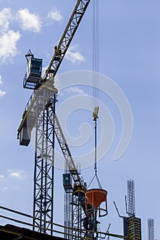 Construction site. Part of tower crane against blue sky.