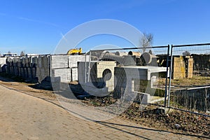 Construction site with pipe and concrete for building houses surrounded with fencing