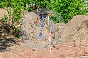 A construction site with pipe and a theodolite