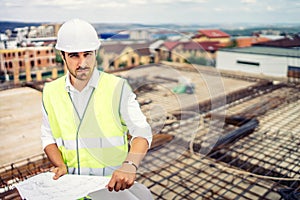 Construction site, portrait of man wearing hardhat and safety equipment on building site