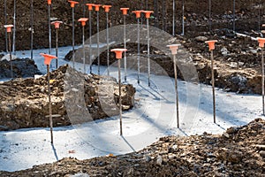 Construction site with rebar in poured footings for a building