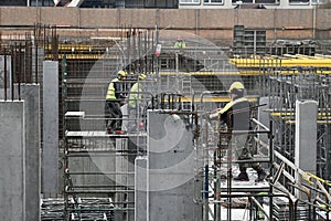 Construction site with reinforcement works with a group of three workers in work clothes