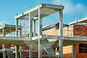 Construction site residential housing development, red brick wall, reinforced concrete pillars, staircase, unfinished in progress