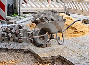 Construction site in road construction paving stone wheelbarrow