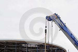 Construction site with scaffolding and cranes for moving of a building materials