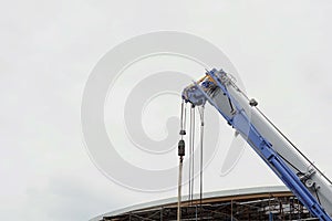 Construction site with scaffolding and cranes for moving of a building materials