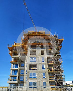 Construction site with scaffoldings and a crane arm