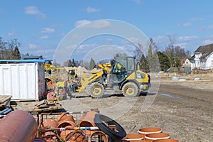 Construction site with several cranes and various materials in front of some earthmovers in Berlin