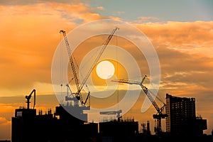 Construction site silhouette on tower building rooftop twilight