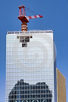 construction site of a skyscraper with a crane on the roof