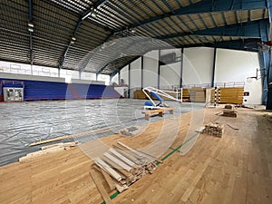 Construction site of sports hall, basketball court renovation, school gym indoor changing hardwood parquet flor and