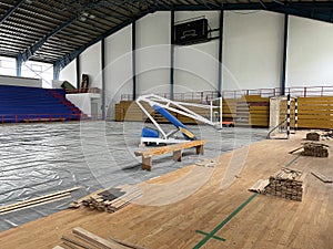 Construction site of sports hall, basketball court renovation, school gym indoor changing hardwood parquet flor and