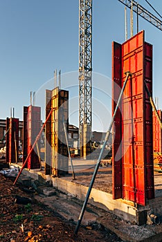 Construction site with steel formworks and reinforcing bars for pillars ready for concrete