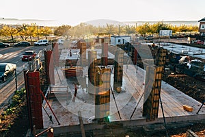 Construction site with steel formworks and reinforcing bars for pillars ready for concrete