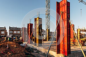 Construction site with steel formworks and reinforcing bars for pillars ready for concrete