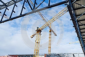 Construction site with steel frame structure and crane.