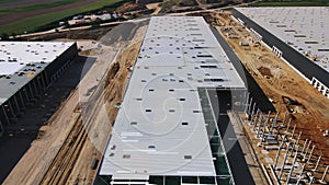 Construction site with steel frame structure of warehouse building, aerial view