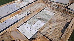 Construction site with steel frame structure of warehouse building, aerial view