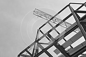 A construction site with steel framing and a yellow construction crane