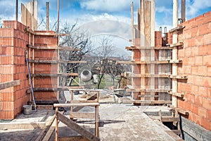 Construction site, tools, wheel barrow, sand and bricks at new house building, cement mixer machine