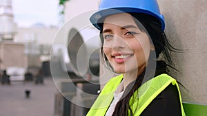 On construction site on the top of the building looking in front of the camera smiling large and have a pretty face