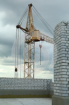 Construction site with tower crane near unfinished building