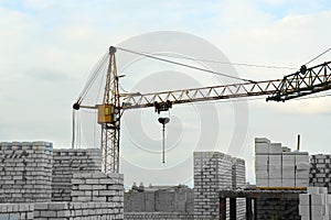 Construction site with tower crane near unfinished building