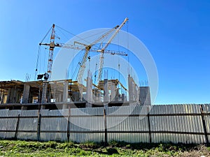 Construction site with tower cranes with hydraulic boom pouring concrete and foundation with cranes