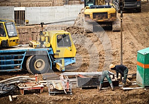 Construction site with trucks and workers on sand