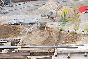 Construction site. View from top. Wheelbarrow and concrete mixer.