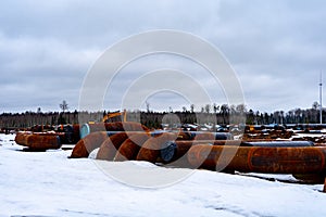 Construction site with a warehouse of metal and plastic pipes of large diameter for the needs of the gas and oil industry. Pipes