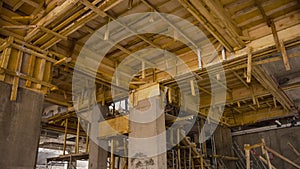 Construction site with wooden scaffolding for ceiling support.