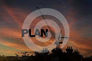 A construction site with the word PLAN written on a crane. The crane is a large, powerful machine that is used to lift heavy