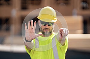 Construction site worker in helmet working outdoor. A builder in a safety hard hat at constructing buildings. American photo