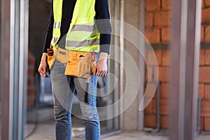 Construction site worker wearing velt with tools
