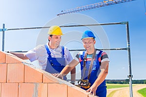 Construction site workers building house with crane