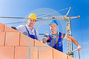 Construction site workers building house with crane