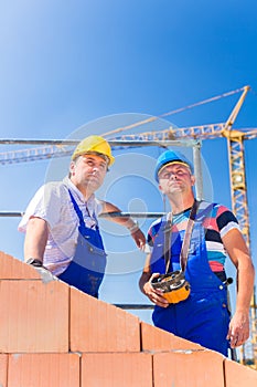 Construction site workers building house with crane