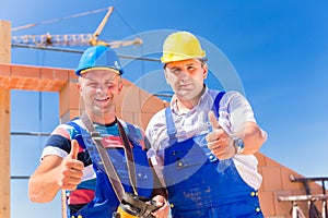 Construction site workers building walls on house