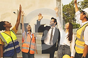 Construction site workers congratulate work together as a team for success.