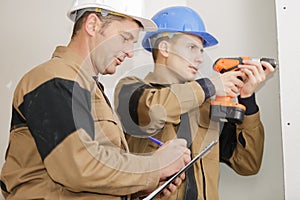 Construction site workers drilling with machine or drill