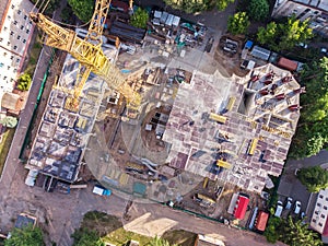 Construction site with yellow tower crane shot from above