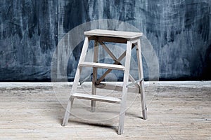 Construction stool near the dark wall, smeared with chalk