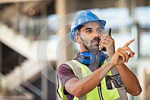 Construction supervisor using walkie talkie