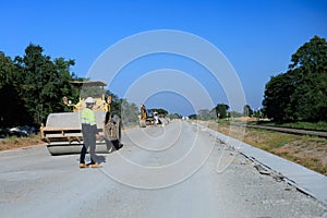 Construction supervisor walking along a new road project during sunrise, symbolizing infrastructure development and future