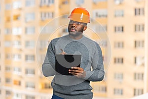 Construction supervisor writes on clipboard.