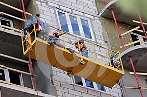 Construction suspended cradle with workers on a newly built high-rise building