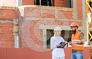 Construction team communication concept. Discuss progress plan. Woman engineer and builder communicate construction site