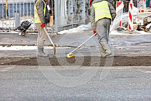 A construction team is patching up the pavement of the carriageway
