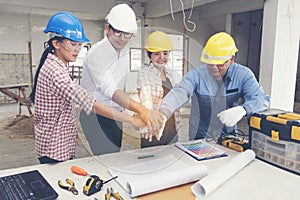 Construction teamwork shaking hands with engineer and foreman in construction site